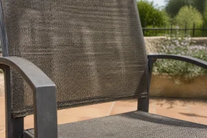 Chaise de jardin en textilène exposée au soleil sur une terrasse